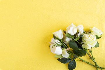 Bouquet of white roses on the yellow background.