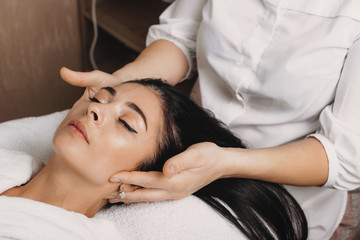 Fototapeta na wymiar Caucasian woman lying on couch and having a spa procedure for her head and face