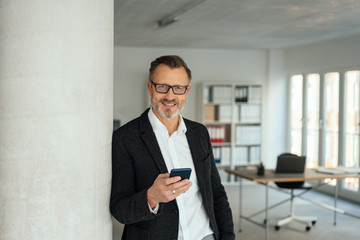 Stylish businessman holding his mobile phone