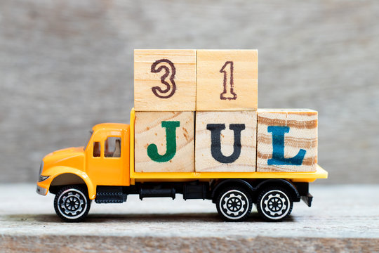 Truck hold letter block in word 31jul on wood background (Concept for date 31 month July)