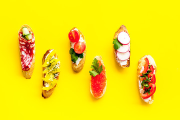Sandwiches assorti pattern on yellow background top-down