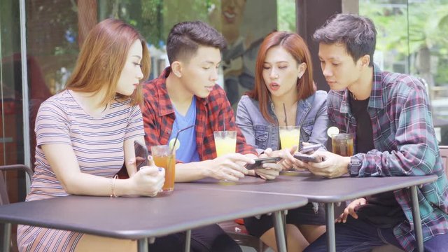 Group of young people using mobile phone in cafe