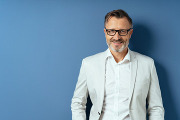 Smiling middle age man in glasses on blue