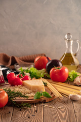 Ingredients for spaghetti bolognese with cherry tomatoes and basil on a wooden table
