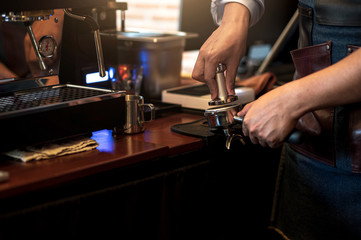 Barista make coffee with espresso machine in cafe. Barista male hands make fresh coffee close-up. Coffee machine and hands professional barista.