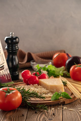 Ingredients for spaghetti bolognese with cherry tomatoes and basil on a wooden table