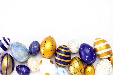 Happy Easter. Frame for text made of easter eggs trendy colored classic blue, white and golden on white. Minimal style, top view, flatlay, copy space