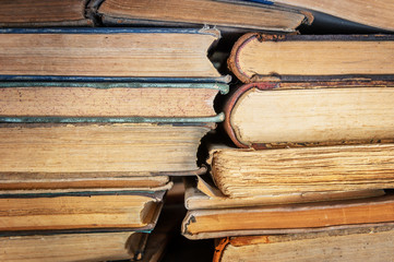 stack of old books on a library shelf