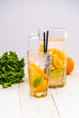 lemonade with citrus in a decanter. on white background. cocktail.