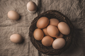 Organic eco eggs in nest on rustic table, Easter