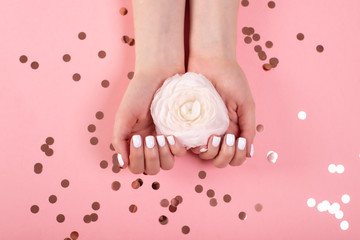 Hands of a beautiful woman on a colorful background. Delicate palm with natural manicure, clean skin. Light pink nails.