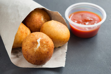 Fried Risotto Arancini stuffed with cheese, served with tomato sauce