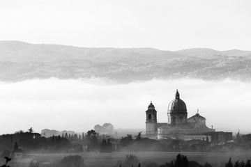 Surreal view of Santa Maria degli Angeli papal church (Assisi) on a background of fog