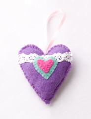 Toys made of felt on a white background, colored heart