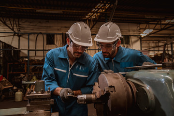 The Industry engineering wearing safety uniform used Vernier caliper to measure the object control operating machine working in industry factory.