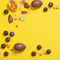 Easter yellow background with chocolatte eggs and  candy