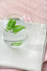 Glass of fresh water with mint on table