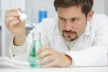 male researcher holding a test tube in the lab