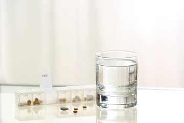 Glass of clean water with pills on table