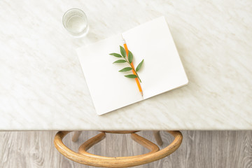 Glass of water with notebook on table