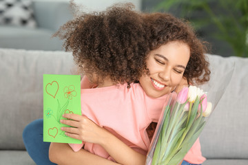 Little African-American girl greeting her mother at home