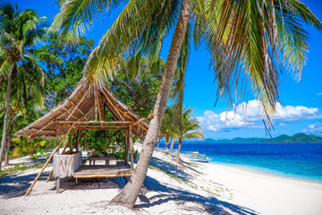 Beach hut under palm tree on the beach. Black island, Coron, Philippines