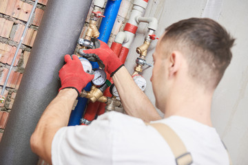 plumber installing water equipment - meter, filter and pressure reducer