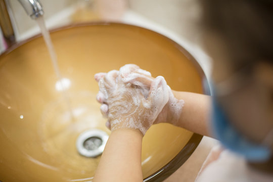 Pretty Little Asian Kazakh Girl In Mask Washing Her Hands. Person, Man, Woman In Mask.