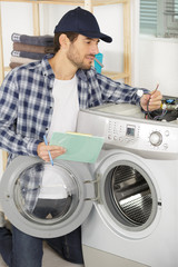 man repairs the electronics of the washing machine
