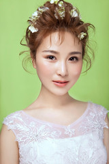 Asian girl wearing flowers headdress in green background