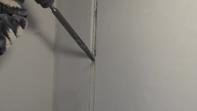 Worker breaks a concrete wall with a perforator chisel