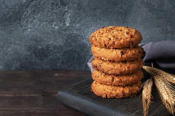 Homemade cookies with cereals and seeds. Oatmeal crackers on a wooden background. Copy space.