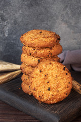 Homemade cookies with cereals and seeds. Oatmeal crackers on a wooden background. Copy space.