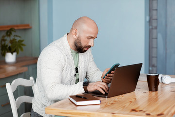 Naklejka premium An attractive man is discussing business with business partners on the phone. A young man checks his mail at the beginning of the working day. Business, work, work at home