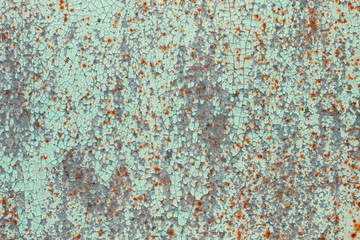 Old peeling turquoise paint with spots of rust on a sheet of metal. Abstract trendy modern texture background