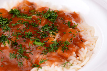 Rice with beef stew with green beans and vegetables served in white plate over light rustic wooden table.