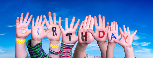 Children Hands Building Colorful Word Birthday. Blue Sky As Background