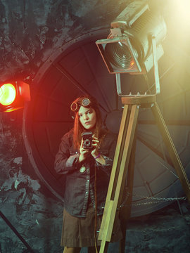 Beautiful steampunk teen girl  in goggles with old camera