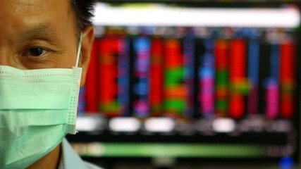 Trader or broker wear a hygienic mask with stock exchange monitor , Chiangmai Thailand - Powered by Adobe