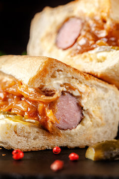 American cuisine. Homemade hot dog with sausage, pickled cucumbers and onions, with garlic sauce. Ketchup and coffee in a disposable glass mum. background image, copy space text