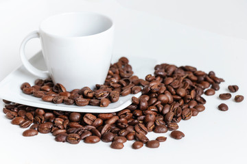 close up of white coffee cup in porcelain and grains of coffee isolated on white background with copy space.
