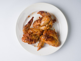 Pickled fried chicken wings on a white plate. View from above
