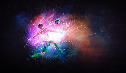 Boy playing soccer hitting the ball