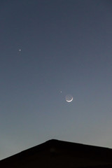 Crescent moon close approach to star. Earthshine is a soft, faint glow on dark side of moon; occurs...