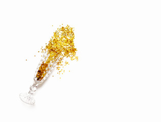 Splashes of gold spangles of stars from a glass figurative glass on a delicate beige background. Ready-made layout for congratulations