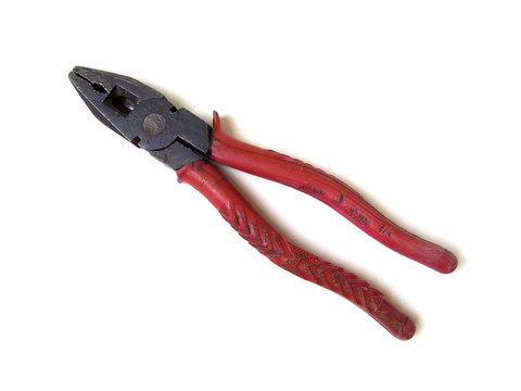 Close up of red handle old rusty pliers isolated on white background. Hand tool.