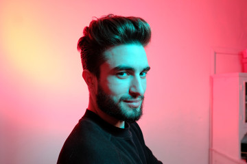 Beautiful caucasian young man portrait isolated on multicolored neon light backgroud. Young, smiling, surprised, screaming. Human emotions, facial expression concept. Trendy colors.Advertising concept
