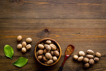 Nutmeg - spices in powder and whole nuts - on wooden background top-down copy space