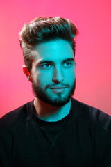 Beautiful caucasian young man portrait isolated on multicolored neon light backgroud. Young, smiling, surprised, screaming. Human emotions, facial expression concept. Trendy colors.Advertising concept