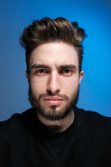 Beautiful caucasian young man portrait isolated on multicolored neon light backgroud. Young, smiling, surprised, screaming. Human emotions, facial expression concept. Trendy colors.Advertising concept